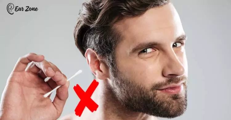 Blog image of a man using Q tips or cotton earbuds. Blog on How to Relieve Itchy Ears