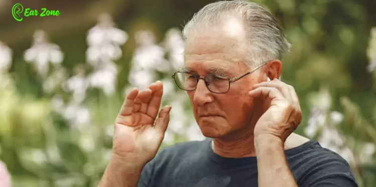 Getting Used To Hearing Aids. Image of a man adjusting hearing aids
