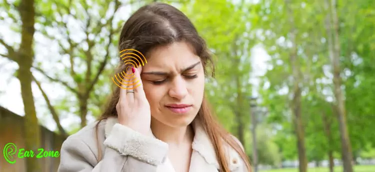 Image of a lady disturbed by hearing aid feedback. Blog on Do Hearing Aids Cause Hearing Loss?